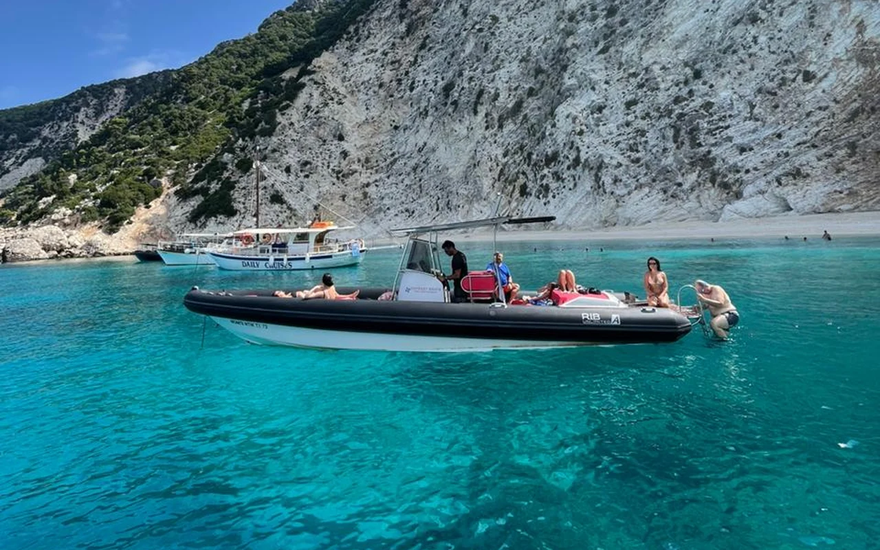 Επισκέπτες σε σκάφος της Odyssey Boats μπροστά στους λευκούς βράχους